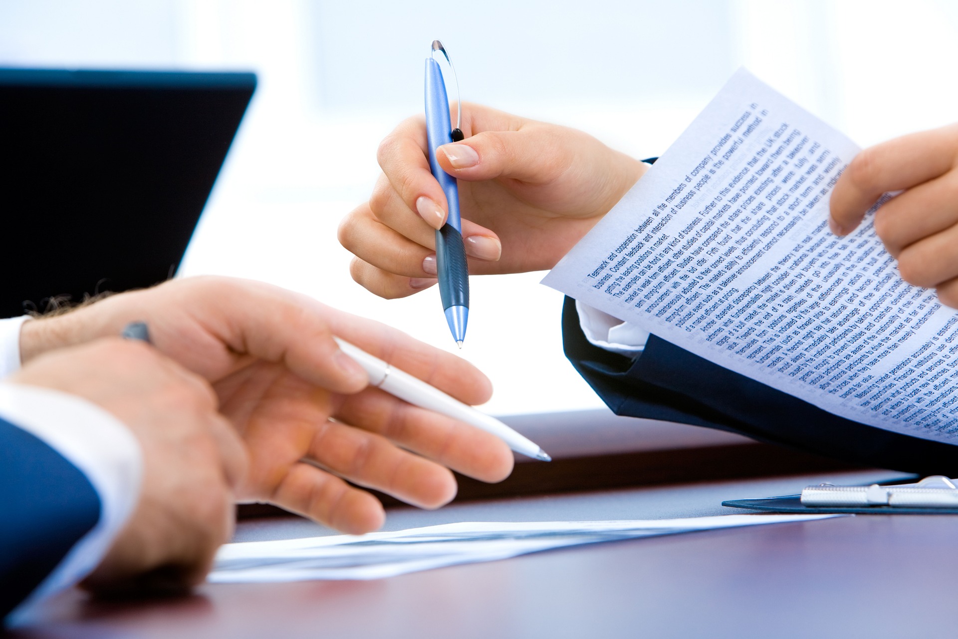 Two people reviewing funding paperwork across a desk